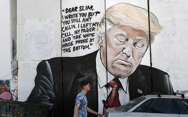 A man walks past a new piece of graffiti depicting US President Donald Trump on the Israeli separation barrier separating the West Bank town of Bethlehem from Jerusalem on October 15, 2017. (AFP Photo/Thomas Coex) A man walks past a new piece of graffiti depicting US President Donald Trump on the Israeli separation barrier separating the West Bank town of Bethlehem from Jerusalem on October 15, 2017. (AFP Photo/Thomas Coex)