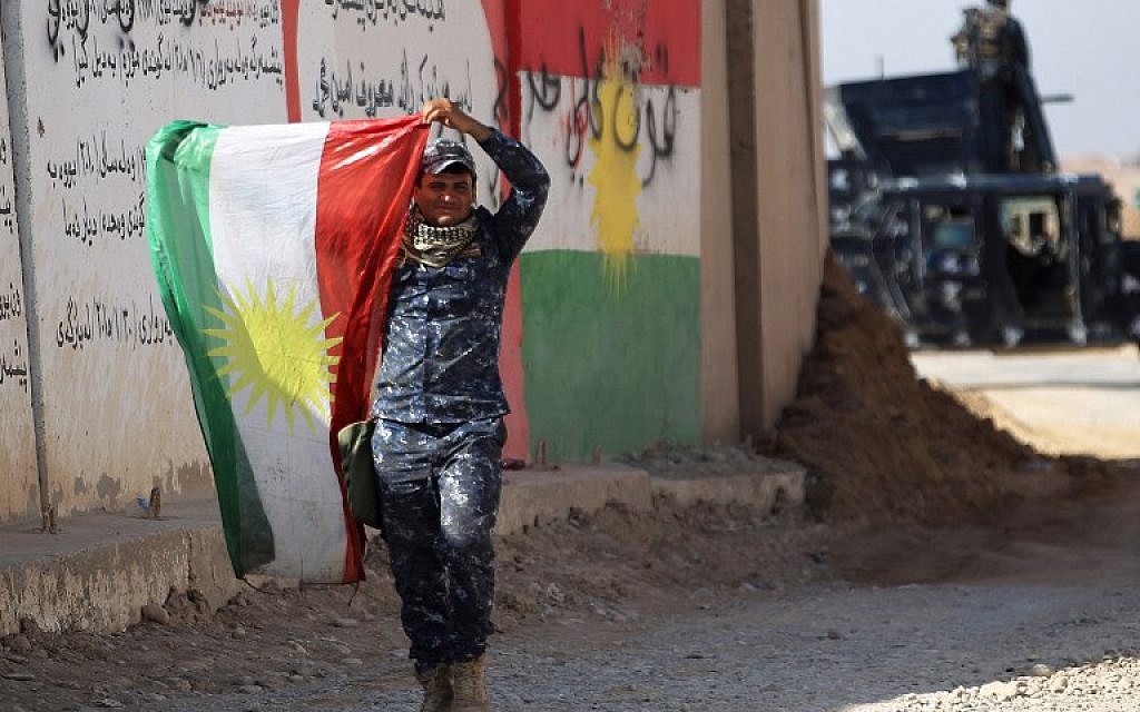 A member of the Iraqi forces holds up a Kurdish flag as they advance towards the city of Kirkuk during an operation against Kurdish fighters on October 16, 2017. (AFP/AHMAD AL-RUBAYE)