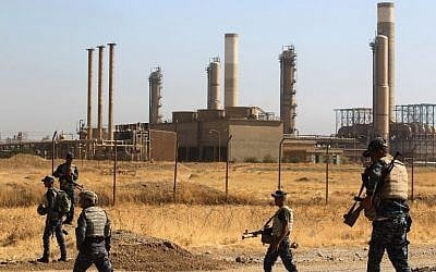 Iraqi forces walk past an oil production plant as they head towards the city of Kirkuk during an operation against Kurdish fighters on October 16, 2017. (AFP Photo/ Ahmad Al-Rubaye)