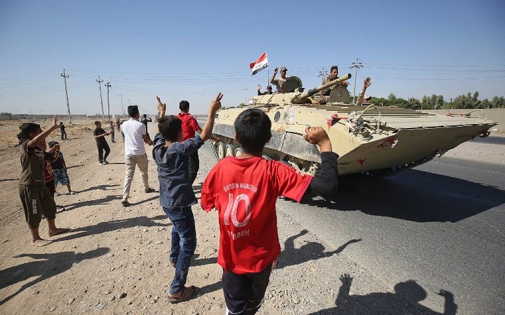 Iraqis wave to Iraqi forces as they arrive in the first neighbourhood on the southern outskirts of Kirkuk on October 16, 2017. 
(AFP/AHMAD AL-RUBAYE)