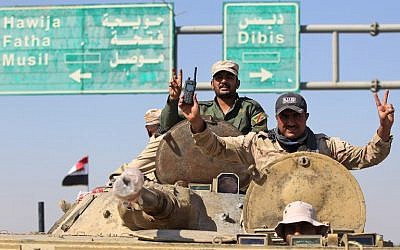 Iraqi forces flash the sign for victory as they advance in the southern outskirts of Kirkuk towards the city during an operation against Kurdish fighters on October 16, 2017. (AFP PHOTO / AHMAD AL-RUBAYE)