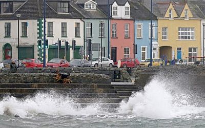 A woman walks her dogs beside the stormy sea in the coastal village of Donaghadee on the Irish Sea coast, east of Belfast in Northern Ireland, on October 16, 2017 as Northern Ireland braces for the passing of the storm Ophelia. (AFP PHOTO/Paul FAITH)