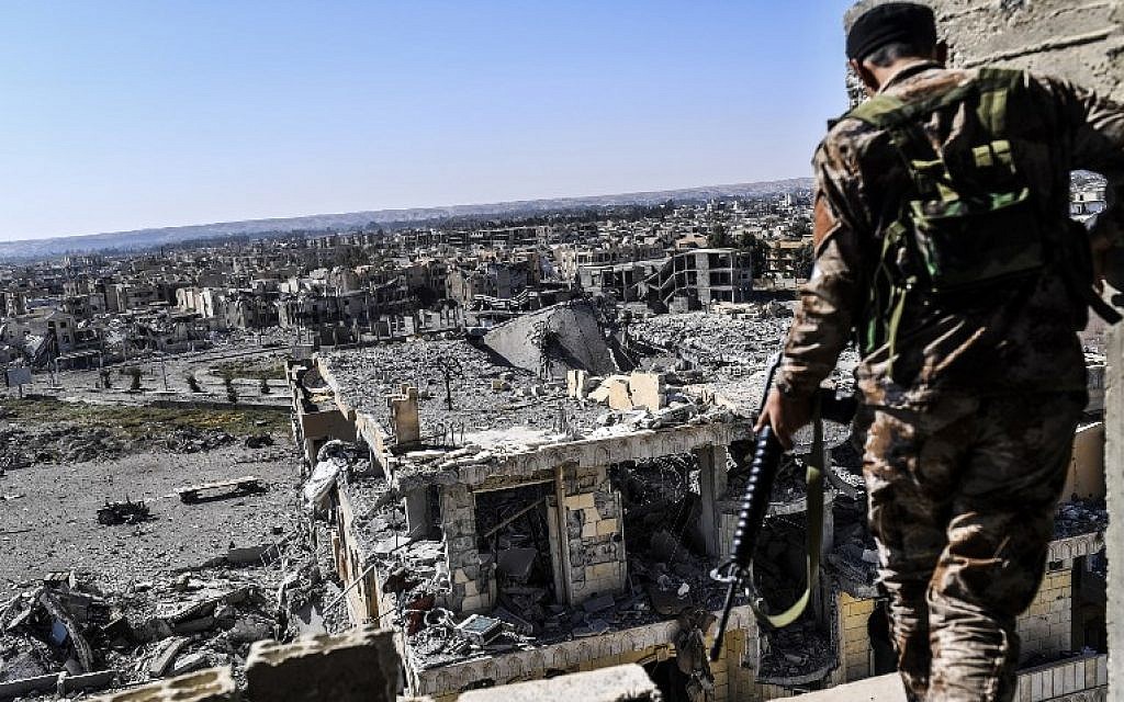 A member of the Syrian Democratic Forces (SDF), backed by US special forces, walks on a building near Raqqa's stadium as they clear the last positions on the frontline on October 16, 2017. AFP / BULENT KILIC) A member of the Syrian Democratic Forces (SDF), backed by US special forces, walks on a building near Raqqa's stadium as they clear the last positions on the frontline on October 16, 2017. AFP / BULENT KILIC)