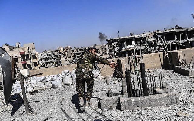 Members of the Syrian Democratic Forces, backed by US special forces, walk on a building near Raqqa's central hospital as they clear the last positions on the frontline in the Islamic State group jihadists crumbling stronghold, October 16, 2017.
(AFP/BULENT KILIC) Members of the Syrian Democratic Forces, backed by US special forces, walk on a building near Raqqa's central hospital as they clear the last positions on the frontline in the Islamic State group jihadists crumbling stronghold, October 16, 2017.
(AFP/BULENT KILIC)
