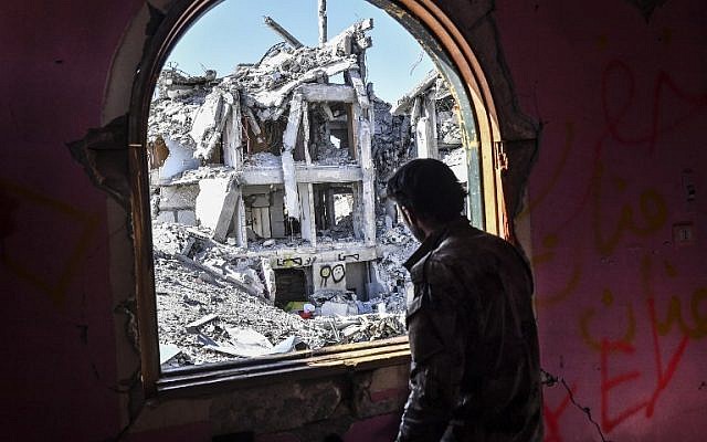 A member of the Syrian Democratic Forces (SDF), backed by US special forces, looks out from a building at the front line in Raqqa on October 16, 2017 in the Islamic State (IS) jihadist group's crumbling stronghold. (AFP PHOTO/BULENT KILIC) A member of the Syrian Democratic Forces (SDF), backed by US special forces, looks out from a building at the front line in Raqqa on October 16, 2017 in the Islamic State (IS) jihadist group's crumbling stronghold. (AFP PHOTO/BULENT KILIC)