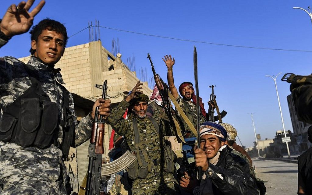 Members of the Syrian Democratic Forces (SDF), backed by US special forces, celebrate at the frontline in the Islamic State (IS) group jihadists crumbling stronghold of Raqqa on October 16, 2017. (AFP PHOTO / BULENT KILIC)