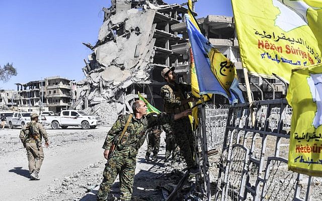 Members of the Syrian Democratic Forces (SDF), backed by US special forces, place their flags at the iconic Al-Naim square in Raqa on October 17, 2017. (Bulent Kilic/AFP) Members of the Syrian Democratic Forces (SDF), backed by US special forces, place their flags at the iconic Al-Naim square in Raqa on October 17, 2017. (Bulent Kilic/AFP)