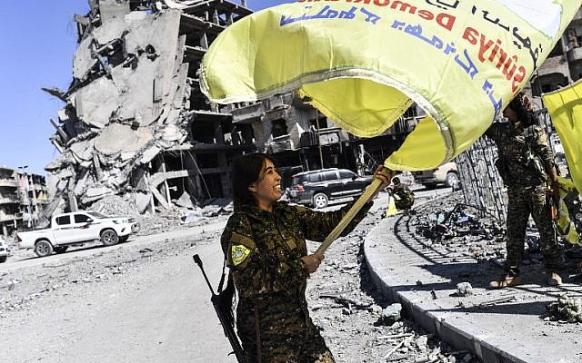 Rojda Felat, a Syrian Democratic Forces (SDF) commander, waves her group's flag at the iconic Al-Naim square in Raqa on October 17, 2017. (Bulent Kilic/AFP) Rojda Felat, a Syrian Democratic Forces (SDF) commander, waves her group's flag at the iconic Al-Naim square in Raqa on October 17, 2017. (Bulent Kilic/AFP)