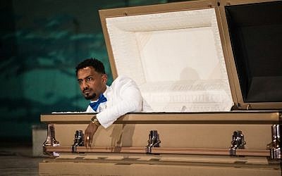 Ethiopian film director Zekarias Mesfin surprises the audience by appearing from inside a coffin on the stage of the National Theater of Ethiopia, during the premiere of his film "Ewir Amora Kelabi" in Addis Ababa, October 16, 2017. (AFP/Zacharias ABUBEKER)