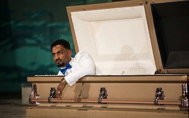 Ethiopian film director Zekarias Mesfin surprises the audience by appearing from inside a coffin on the stage of the National Theater of Ethiopia, during the premiere of his film "Ewir Amora Kelabi" in Addis Ababa, October 16, 2017. (AFP/Zacharias ABUBEKER) Ethiopian film director Zekarias Mesfin surprises the audience by appearing from inside a coffin on the stage of the National Theater of Ethiopia, during the premiere of his film "Ewir Amora Kelabi" in Addis Ababa, October 16, 2017. (AFP/Zacharias ABUBEKER)