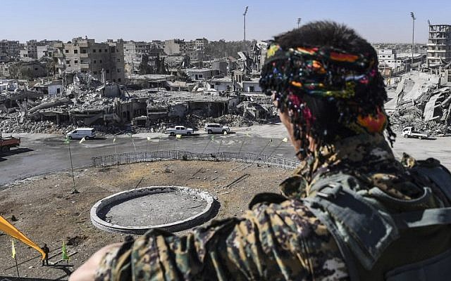 A member of the Syrian Democratic Forces (SDF) stands at a position overlooking the iconic Al-Naim square in Raqa on October 18, 2017. (AFP/Bulent Kilic) A member of the Syrian Democratic Forces (SDF) stands at a position overlooking the iconic Al-Naim square in Raqa on October 18, 2017. (AFP/Bulent Kilic)
