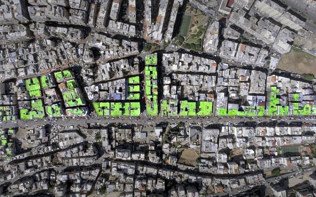 An aerial view of the word "Peace" in Arabic painted on the roofs of 85 buildings in Tripoli's Syria street which separates the Sunni neighborhood of Bab al-Tabbaneh from the Alawite neighborhood of Jabal Mohsen.
The project has been three years in the making, with the artists, 34-year-old twins Mohamed and Omar Kabbani, researching and rejecting multiple locations in their native Lebanon before settling on Tripoli. (AFP PHOTO / ASHEKMAN / Handout)