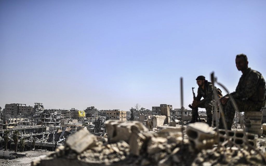 Fighters from the Syrian Democratic Forces stand guard on a rooftop in Raqqa on October 20, 2017, after retaking the city from the Islamic State. (AFP Photo/Bulent Kilic) Fighters from the Syrian Democratic Forces stand guard on a rooftop in Raqqa on October 20, 2017, after retaking the city from the Islamic State. (AFP Photo/Bulent Kilic)