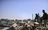 Fighters from the Syrian Democratic Forces stand guard on a rooftop in Raqqa on October 20, 2017, after retaking the city from the Islamic State. (AFP Photo/Bulent Kilic)