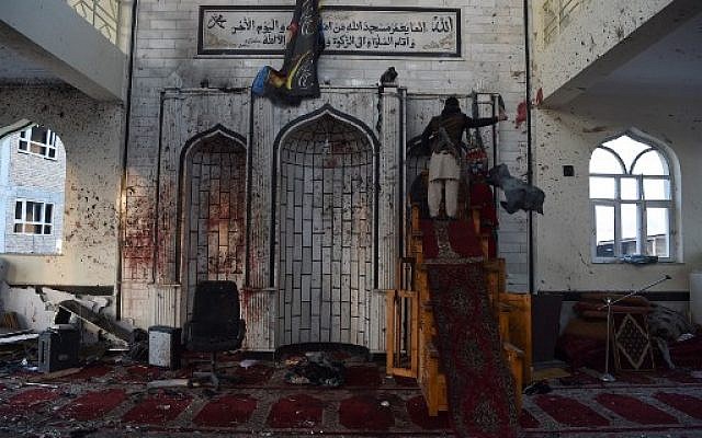 An armed Afghan civilian looks inside the Imam Zaman Shiite mosque which was a the site of a suicide attack during evening prayers, in Kabul on October 21, 2017 (AFP/WAKIL KOHSAR) An armed Afghan civilian looks inside the Imam Zaman Shiite mosque which was a the site of a suicide attack during evening prayers, in Kabul on October 21, 2017 (AFP/WAKIL KOHSAR)