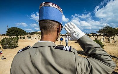 A French officer gives a salute before a grave during a ceremony to mark 75 years since the pivotal WWII battle in the town of El Alamein, about 100 kilometres (62 miles) west of Alexandria, during a visit by Egyptian President Abdel Fattah al-Sisi, on October 21, 2017. (AFP PHOTO / KHALED DESOUKI)