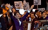 Japan's Prime Minister and ruling Liberal Democratic Party leader Shinzo Abe waves to his supporters in Tokyo while leaving his last stumping speech ahead of the October 22 general election, on October 21, 2017. (AFP Photo/Toshifumi Kitamura)