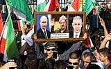 An Iraqi Kurdish man holds a picture frame with portraits of Russian President Vladimir Putin (L), Israeli Prime Minister Benjamin Netanyahu (R), and Iraqi Kurdistan President Massoud Barzani during a demonstration outside the UN Office in Irbil, the capital of the autonomous region, on October 21, 2017. (AFP Photo/Safin Hamed)
