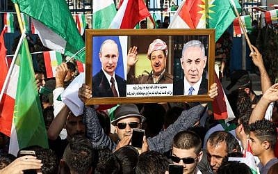 An Iraqi Kurdish man holds a picture frame with portraits of Russian President Vladimir Putin (L), Israeli Prime Minister Benjamin Netanyahu (R), and Iraqi Kurdistan President Massoud Barzani during a demonstration outside the UN Office in Irbil, the capital of the autonomous region, on October 21, 2017. (AFP Photo/Safin Hamed)