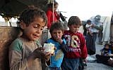 A Syrian child holds a piece of cauliflower in his hand at the Ash'ari camp for the displaced in the rebel-held eastern Ghouta area outside the capital Damascus on October 25, 2017. (Amer Almohibany/AFP)