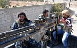 Syrian soldiers and pro-regime militiamen man a heavy machine-gun mounted on the back of a pickup truck as they ride in the recently retaken desert town of Al-Qaryatain on October 26, 2017. (AFP Photo/Stringer)