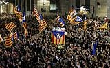 A flag with the text in Catalan "The people lead" is held up as people gather to celebrate the proclamation of a Catalan republic at the Sant Jaume square in Barcelona on October 27, 2017. (AFP PHOTO / PAU BARRENA)