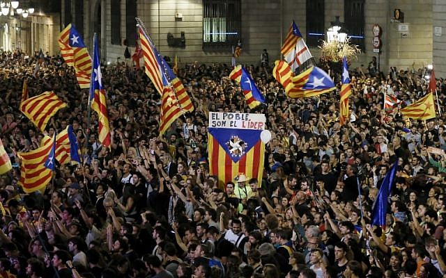 A flag with the text in Catalan "The people lead" is held up as people gather to celebrate the proclamation of a Catalan republic at the Sant Jaume square in Barcelona on October 27, 2017. (AFP PHOTO / PAU BARRENA) A flag with the text in Catalan "The people lead" is held up as people gather to celebrate the proclamation of a Catalan republic at the Sant Jaume square in Barcelona on October 27, 2017. (AFP PHOTO / PAU BARRENA)