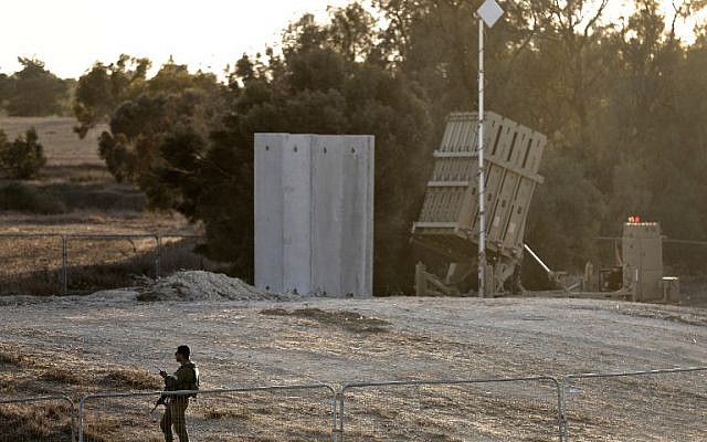 Illustrative: An Israeli soldier stands guard next to Israel's Iron Dome defense system, designed to intercept and destroy incoming short-range rockets and artillery shells, deployed close to the Israeli border with the Gaza Strip, near Kibbutz Kissufim in southern Israel, on October 30, 2017. (AFP Photo/Menahem Kahana) Illustrative: An Israeli soldier stands guard next to Israel's Iron Dome defense system, designed to intercept and destroy incoming short-range rockets and artillery shells, deployed close to the Israeli border with the Gaza Strip, near Kibbutz Kissufim in southern Israel, on October 30, 2017. (AFP Photo/Menahem Kahana)