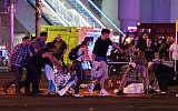 An injured person is tended to at the intersection of Tropicana Avenue and Las Vegas Boulevard after a mass shooting at a country music festival nearby on October 2, 2017 in Las Vegas, Nevada. (Ethan Miller/Getty Images/AFP)
