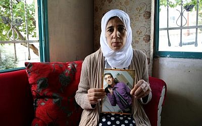 Manal al-Sayed holds up a picture of her son Hisham, held captive in Gaza by the Hamas terrorist group, in 2016. (Yoav Lemmer/AFP)