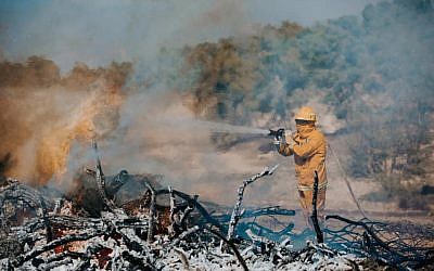 An Israeli firefighter puts out a blaze as part of an international natural disaster preparedness exercise in central Israel on October 24, 2017. (Fire and Rescue Authority)