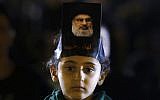 A Hezbollah supporter listens to Hezbollah leader Sheik Hassan Nasrallah, pictured, as he delivers a message via video link, during the ninth of Ashura, a 10-day ritual commemorating the death of Imam Hussein, in a southern suburb of Beirut, Lebanon, Saturday, Sept. 30, 2017 (AP Photo/Hassan Ammar)
