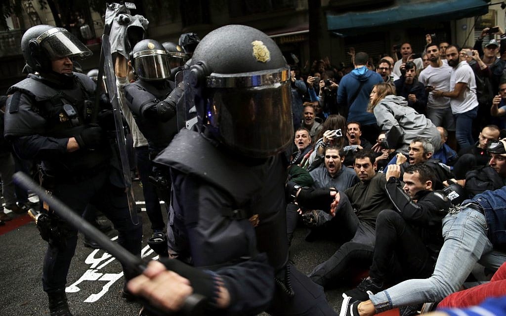 Spanish National Police try to dislodge pro-referendum supporters sitting down on a street in Barcelona, October 1, 2017. (AP/Manu Fernandez)