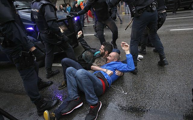 Three man hold to each other as they try to block a Spanish police van from approaching a voting site to prevent would-be voters from voting at a school assigned to be a polling station by the Catalan government in Barcelona, Spain, 1 October 2017. (AP Photo/Emilio Morenatti) Three man hold to each other as they try to block a Spanish police van from approaching a voting site to prevent would-be voters from voting at a school assigned to be a polling station by the Catalan government in Barcelona, Spain, 1 October 2017. (AP Photo/Emilio Morenatti)