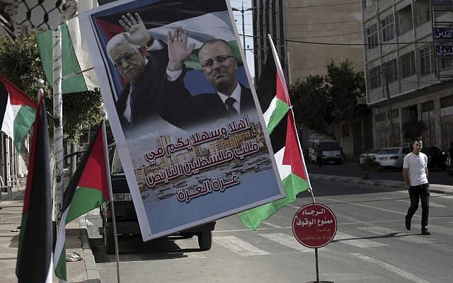 A poster of Palestinian Authority President Mahmoud Abbas and PA Prime Minister Rami Hamdallah hangs on a street in Gaza City, October 1, 2017 (AP Photo/Khalil Hamra) A poster of Palestinian Authority President Mahmoud Abbas and PA Prime Minister Rami Hamdallah hangs on a street in Gaza City, October 1, 2017 (AP Photo/Khalil Hamra)