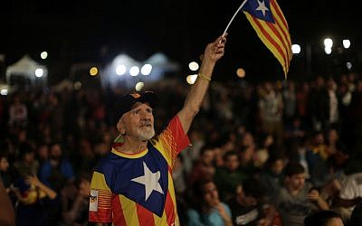 A man waves a ''estelada'' or Catalonia independence flag during a gathering at Plaza Catalonia in Barcelona, Spain, Sunday evening, 1 October 2017. (AP Photo/Emilio Morenatti)