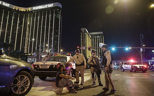 Police officers stand at the scene of a shooting near the Mandalay Bay resort and casino on the Las Vegas Strip, Sunday, Oct. 1, 2017, in Las Vegas. (AP Photo/John Locher) Police officers stand at the scene of a shooting near the Mandalay Bay resort and casino on the Las Vegas Strip, Sunday, Oct. 1, 2017, in Las Vegas. (AP Photo/John Locher)