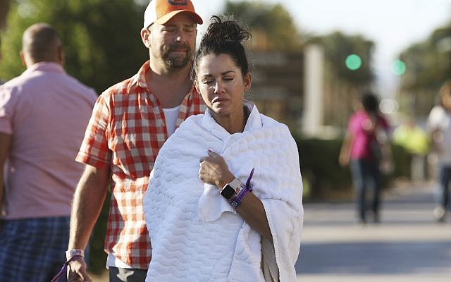 Melissah Burke and her husband Stephen, of Seattle, walk along the Las Vegas Strip near Mandalay Bay hotel and casino Monday, Oct. 2, 2017, in Las Vegas, after a mass shooting at a music festival there the night before. (AP Photo/Ronda Churchill) Melissah Burke and her husband Stephen, of Seattle, walk along the Las Vegas Strip near Mandalay Bay hotel and casino Monday, Oct. 2, 2017, in Las Vegas, after a mass shooting at a music festival there the night before. (AP Photo/Ronda Churchill)