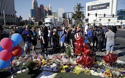 People pause at a Las Vegas memorial for the victims of the mass shooting at a concert in the city three days earlier, October 4, 2017. (AP/John Locher)