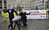 In this file photo from September 13, 2017, activists from the International Campaign to Abolish Nuclear Weapons (ICAN) protest against the conflict between North Korea and the USA with masks of North Korean ruler Kim Jong Un, right, and US president Donald Trump, left, in front of the US embassy in Berlin, Germany. (Britta Pedersen/dpa via AP)