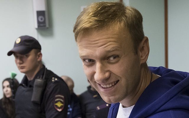 Russian opposition leader Alexei Navalny smiles as he speaks to the media during a break in the hearing on his appeal in a court in Moscow, Russia, Friday, Oct. 6, 2017. The Moscow City Court on Friday upheld a 20-day jail term for Navalny for calling for an unsanctioned protest. (AP Photo/Pavel Golovkin)