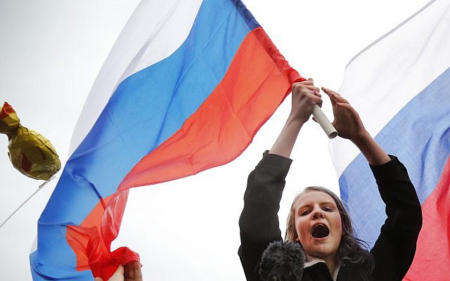 Demonstrators shout slogans and wave Russian flags during a rally in Moscow, Russia October 7, 2017. (AP Photo/Alexander Zemlianichenko)