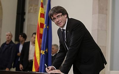 Catalan regional President Carles Puigdemont signs an independence declaration document after a parliamentary session in Barcelona, Spain, Tuesday, Oct. 10, 2017. (AP Photo/Manu Fernandez)
