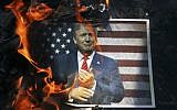 In this Wednesday, Sept. 27, 2017 file photo, a portrait of US President Donald Trump is set on fire by Iranian mourners during the state funeral of Mohsen Hojaji, a young Revolutionary Guard soldier beheaded by the Islamic State group in Syria, in Tehran, Iran. (AP/Ebrahim Noroozi)