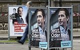 In this photo taken Wednesday, Oct. 11, 2017, a person passes posters of the right-wing Freedom party, FPOE, and the conservative Austrian People's Party, OEVP, from left, in Vienna, Austria, Wednesday, Oct.11, 2017. (AP Photo/Ronald Zak)