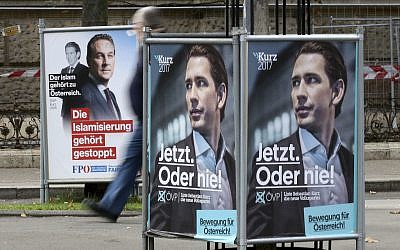 In this photo taken Wednesday, Oct. 11, 2017, a person passes posters of the right-wing Freedom party, FPOE, and the conservative Austrian People's Party, OEVP, from left, in Vienna, Austria, Wednesday, Oct.11, 2017. (AP Photo/Ronald Zak)