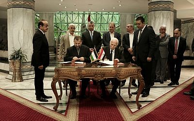 Senior Fatah official Azzam al-Ahmad, center right, and Hamas' representative, Saleh al-Arouri, center left, sign a reconciliation deal during a short ceremony at the Egyptian intelligence complex in Cairo, Egypt, Thursday, October 12, 2017. (AP Photo/Nariman El-Mofty)