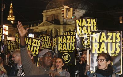 Demonstrators hold posters 'Nazis get off' during a demonstration against the Austrian Freedom Party FPOe in Vienna, Austria, Friday, Oct. 13, 2017. Austria will hold national elections on Sunday, Oct. 15, 2017. (AP Photo/Ronald Zak)