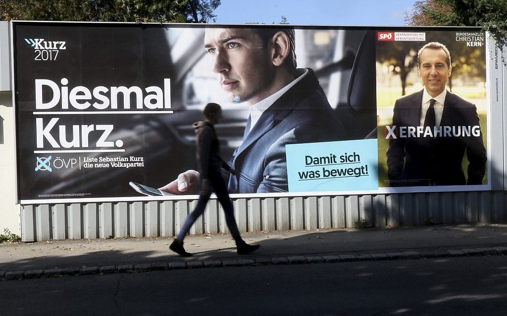 A person passes posters of the conservative Austrian People's Party, OEVP, left,  and the Austrian Social Democrats, SPOE, in Vienna, Austria, October 14, 2017. (AP Photo/Ronald Zak)
