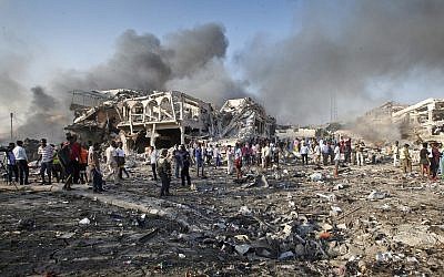 Somalis gather and search for survivors by destroyed buildings at the scene of a blast in the capital Mogadishu, Somalia, October 14, 2017. (AP Photo/Farah Abdi Warsameh)